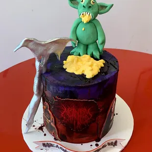 a cake with a green creature on top