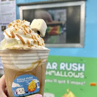 a hand holding a cup of ice cream