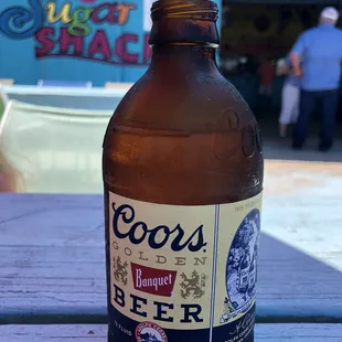 a bottle of beer on a picnic table