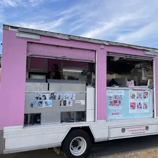 a pink food truck parked on the side of the road