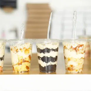 a variety of desserts in plastic cups