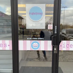 the reflection of a person in a store window