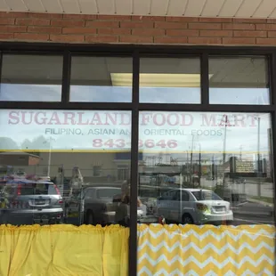 storefront window with yellow curtains