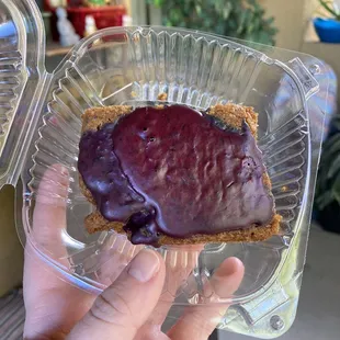 a hand holding a piece of cake