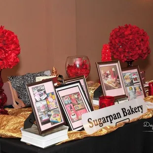 a table with red flowers and pictures