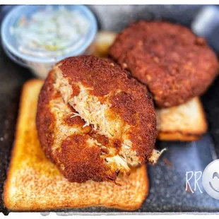 two crab cakes and a side of coleslaw