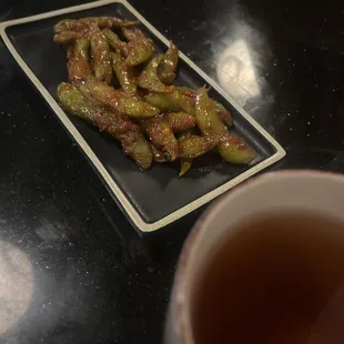 Hot tea and Edamame with spice.
