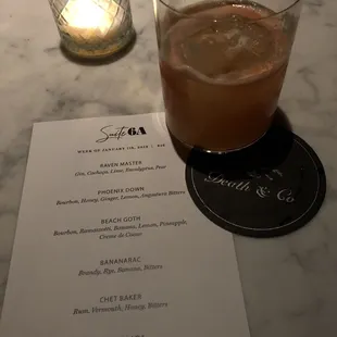 a drink and menu on a marble table
