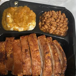 a tray of meat, beans, and mashed potatoes