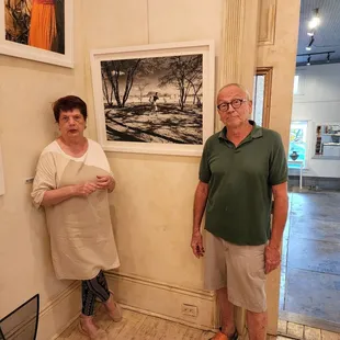 My art in the gallery with the owners of the gallery pictured