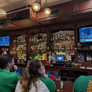 people sitting at a bar watching tv