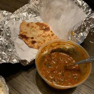 a bowl of curry and a flatbread