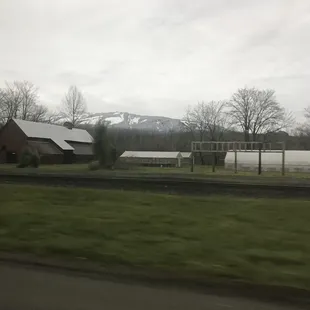 a farm with a snow capped mountain in the background