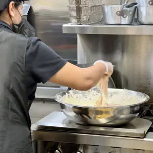 a woman cooking in a kitchen