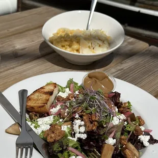 a plate of salad and a bowl of dressing