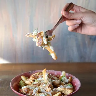 Loaded Chicken Shawarma Fries with pickels, parsely, fresh garlic sauce and a layer of fresh hummus at the bottom so dig deep!