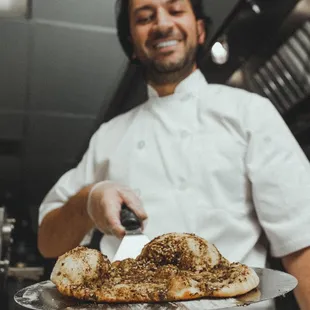 Mankouche Zaatar (Crispy dough with Zaa'tar, Mint Leaves, Tomatos, Olives)