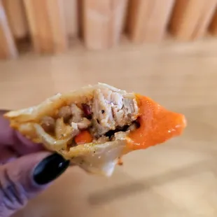 a hand holding a piece of food