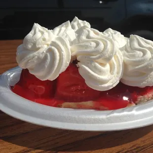 a strawberry pie with whipped cream on top