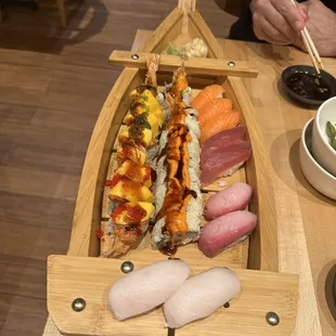 a wooden boat filled with sushi