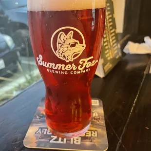 a glass of beer on a coaster