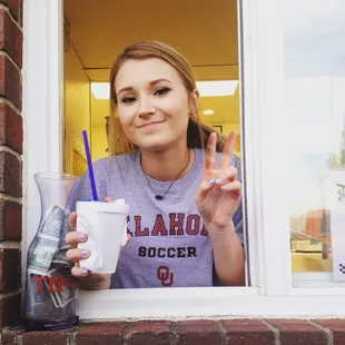 a woman holding up a cup of coffee
