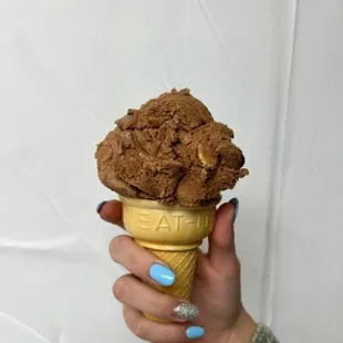 a person holding a cone of ice cream