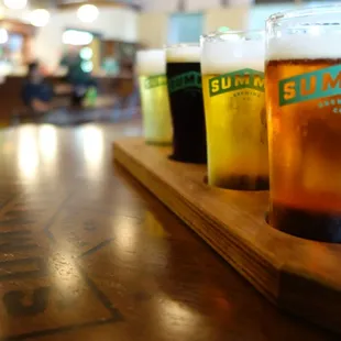 three pints of beer on a wooden tray