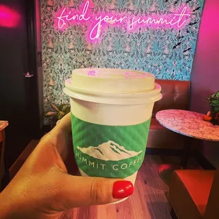 a hand holding a cup of coffee