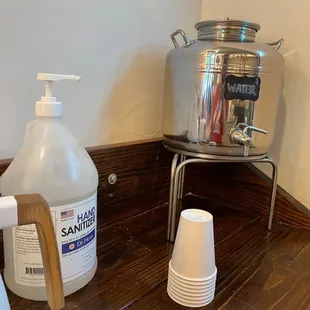 a dispenser and cups on a counter