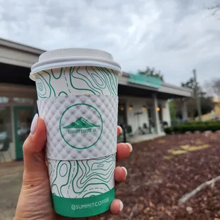 a hand holding a cup of coffee