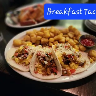 a plate of tacos and tater tots