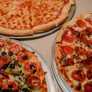 three pizzas on a table
