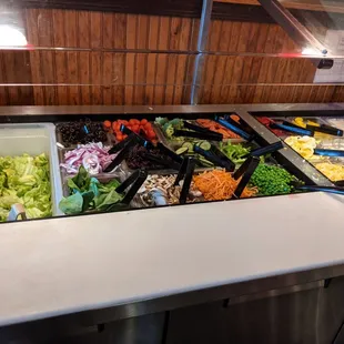 a salad bar with a variety of vegetables