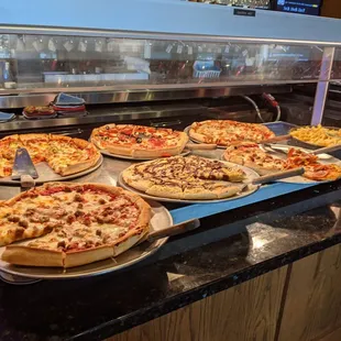 a variety of pizzas on display