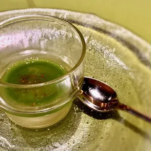 a glass of green tea and a spoon
