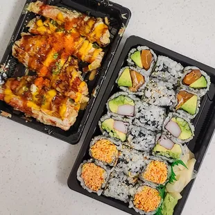 two trays of sushi and rolls