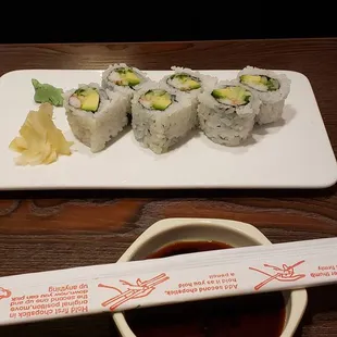 a plate of sushi and a bowl of sauce