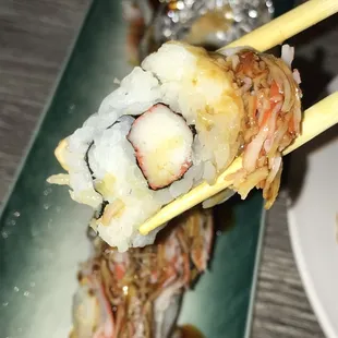 chopsticks holding a piece of sushi