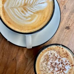 two cups of coffee on a wooden table