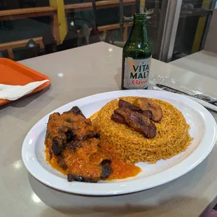 Jollof rice combo with plantains and goat meat.