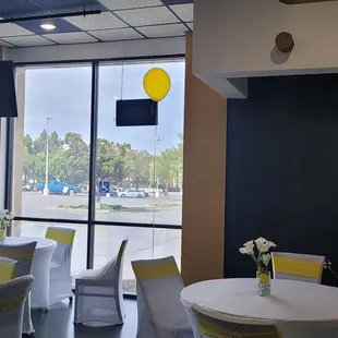 tables and chairs with yellow balloons