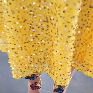 a woman's feet in yellow dress