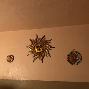three decorative sun faces on a wall