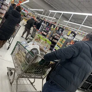 a man pushing a shopping cart in a grocery store