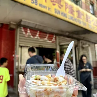 a hand holding a bowl of food