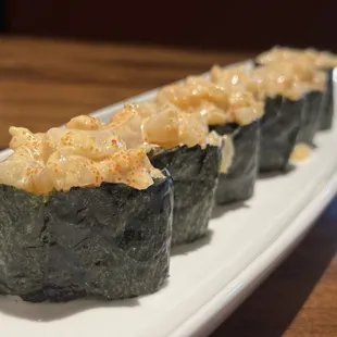 three sushi rolls on a white plate