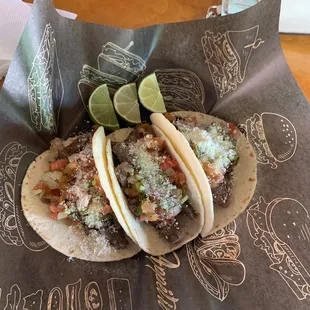 two tacos with lime wedges