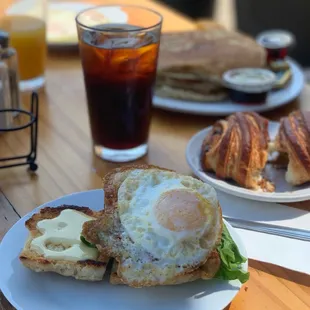 BLT biscuit sandwich with an egg, crusher croissant, sourdough pancakes, cold press, OJ