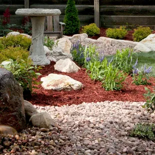a garden with a stone bench